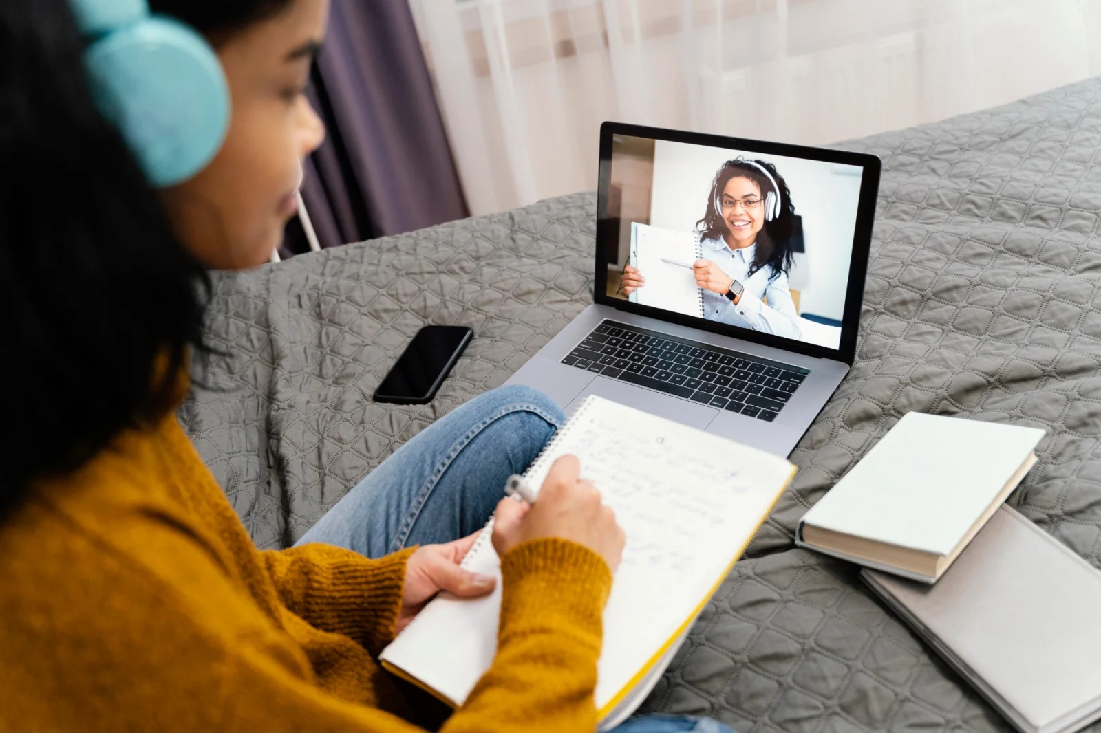 Aluna fazendo anotações durante uma aula online em casa