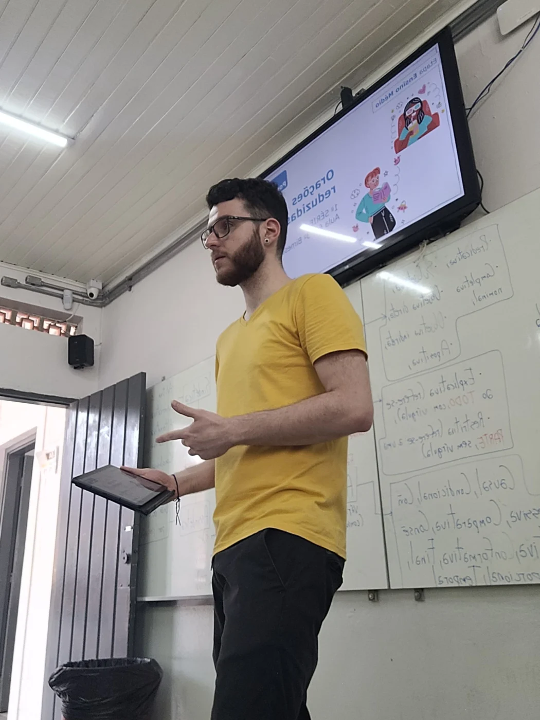 Professor Guilherme Schneider conduzindo uma aula com um tablet na mão